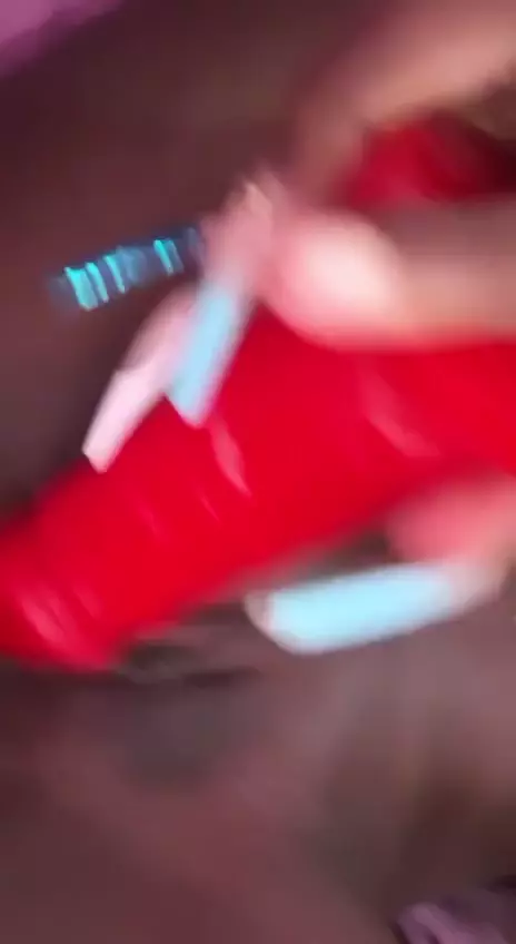 Mujer traviesa usando un vibrador rojo en su coño oscuro y mojado