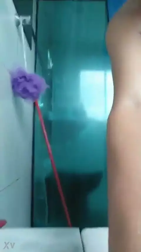 Joven virgen mostrando su cuerpo mojado bajo la ducha en un vídeo casero